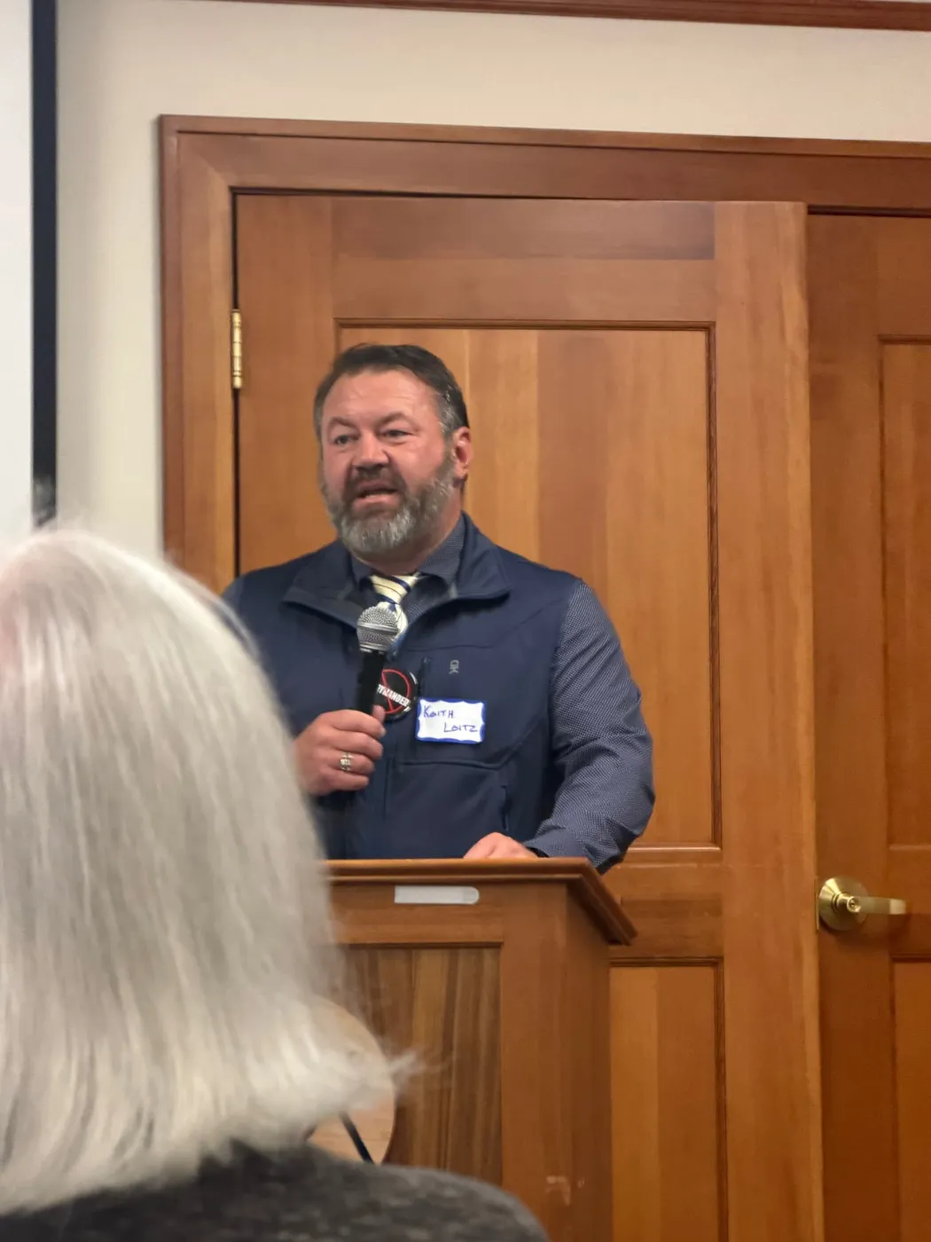 Keith Leitz speaking with a microphone to a community audience